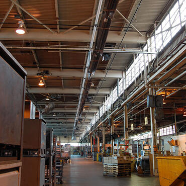 Infrared tube heaters mounted overhead along the length of a manufacturing plant